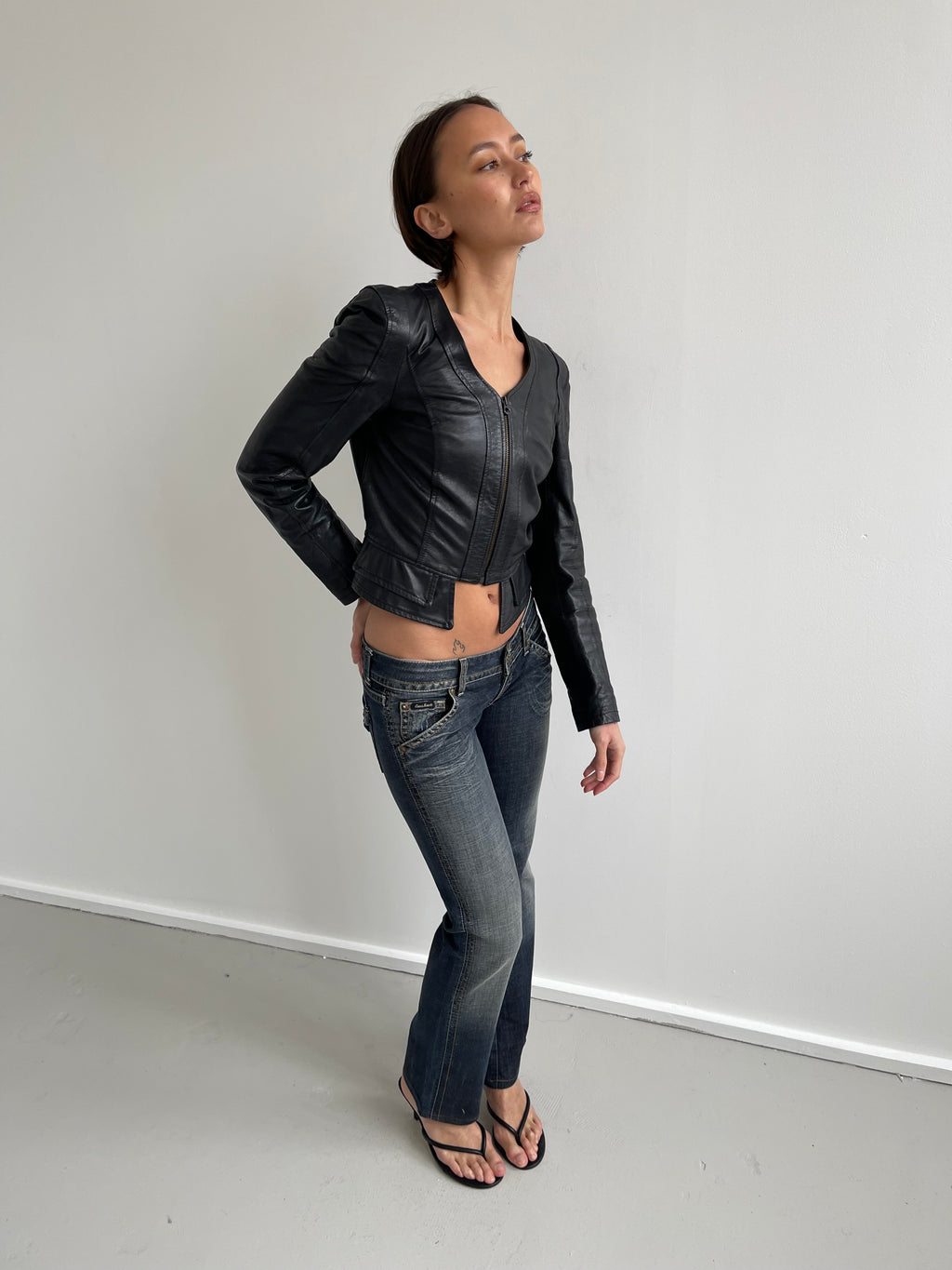 Fitted black leather jacket with panels and low cut neck