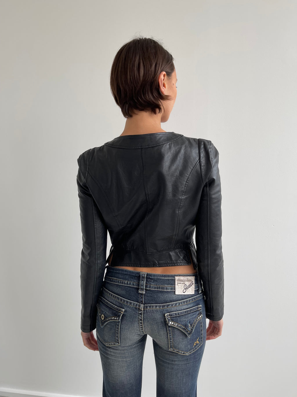 Fitted black leather jacket with panels and low cut neck